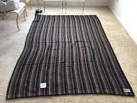 Single blanket laid flat on floor showing full striped pattern