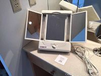 Front view of Conair lighted makeup mirror with tri-fold panels on a vanity surface.