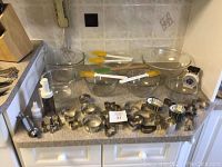 Overview of all items on kitchen counter, including mixing bowls, spatulas, cookie cutters, piping accessories, and tongs.