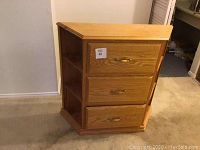 Front view of the solid wood cabinet showing three drawers with metal handles.