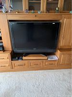 Sharp 48 inch TV housed in a wooden entertainment unit, shown from the front with the screen off.