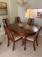 Oval dining table with six chairs shown together