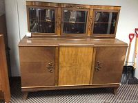 Front view of antique wooden buffet with central burl wood panel and decorative handles