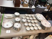 Overall layout of place settings, bowls, cups, saucers and platters