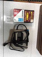 Electric stapler placed with two boxes of staples on a white surface.