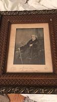 Full view of framed print of Sir John A. Macdonald in carved wooden frame.