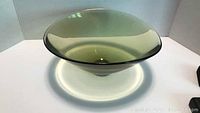 Front view of large olive-green tinted Holmegaard art glass bowl with a wide flared rim showing overall shape and color.