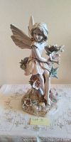 Front view of a 16-inch garden fairy statue sitting on a floral base.