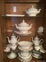 Two shelves of tureens, platter and small decorative plate