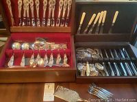Two wooden storage boxes with silver plated flatware set and cream-handled knives and forks.