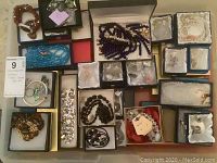 Overhead view of various boxed jewelry pieces including bracelets, brooches and necklaces