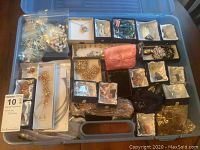 Container with multiple small boxes and bagged jewelry pieces showing assortment