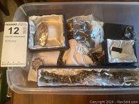 Clear view of various brooches, earrings and necklace in storage bin