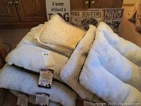 Photo showing cream fleece pet bed with pillow and tags.