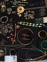 Overview of assorted jewelry pieces laid flat on black surface