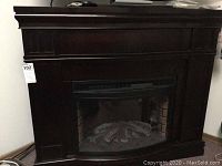 Frontal view of the dark wood electric fireplace showing its size and classic design.