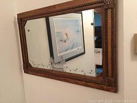Full view of the rectangular mirror displaying the wooden frame with carved details and the etched floral and grapevine decoration on the glass surface.