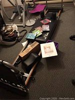 Full view of Aero Pilates reformer board with DVDs, pillow box, and weight basket