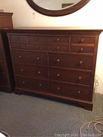 Front view of entire dresser showing nine drawers and wooden knob pulls