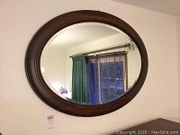 Full front view of oval mirror on wall