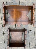 Photo showing front view of both antique wooden shelves, highlighting wood finish and design details.