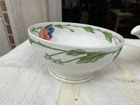 Serving bowl showing floral pattern with green leaves and red and blue flowers, side view
