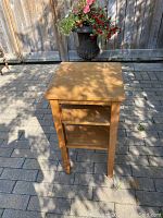 Side view of the handmade wood side table showing two shelves and four straight legs.