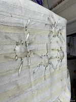 Large view showing five circular glass saucers with attached crystal drops laid on a white textured cloth.