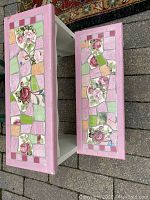 Top view showing the floral mosaic tile inlay on both steps of the stool, with predominant pink border paint on the edges.