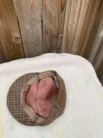 Photo showing the inside and brim of the Biltmore Harris Tweed cap with suede top and soft pinkish lining.