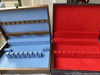 Two flatware storage boxes, one with blue fabric interior and one with red fabric interior, showing the inside compartments and slots for flatware organization.