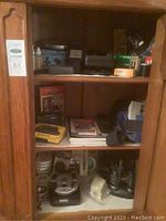 Cabinet shelves filled with electronics, photography books, and film rolls