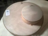 Photo showing both large and small drums on a table, larger Remo Ocean Drum and smaller Buffalo drum.