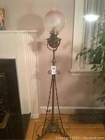 Full view of lamp showing overall height, tripod base, twisted supports and shade