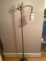 Full-length view of metal floor lamp showing base, column, arm, shade