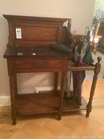 Overall front view showing marble top, drawer, lower shelf, and umbrella stand