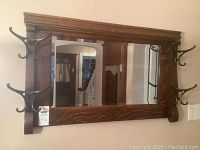 Full front view of oak-framed mirror with hooks