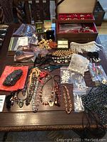 Overall view of costume jewelry assortment including necklaces, bracelets, earrings and charms
