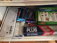 Drawers with vacuum sealer accessories: aluminum foil, parchment paper, Ziploc bags, Reynolds wrap, FoodSaver vacuum seal rolls