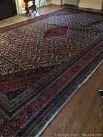 Full view of rug laid on hardwood floor showing overall shape, size and placement.