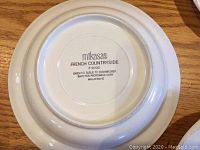 Backstamp of Mikasa French Countryside marking on bottom of plate indicating brand, pattern, and care instructions.