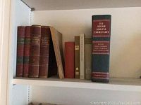 First shelf with seven books including old volumes and The Jerome Biblical Commentary.