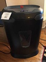 Front view of the black Staples paper shredder showing the clear window panel and shredder body.