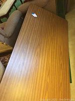 View of the top surface of one folding table showing faux wood grain finish