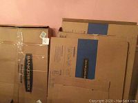 Stack of more than 12 new Large Banker cardboard boxes in tan with blue and black branding. Boxes are unopened and in original condition.