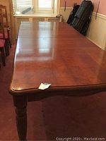 Full view of the wooden dining table with both leaves extended.