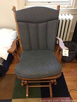 Front view of the wooden glider rocker chair with blue cushioned seat and backrest showing overall condition and design.