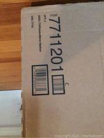 Close-up photo of a TV picture/mirror medium bankers box with barcode and item number 7711201.