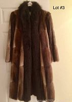 Front view of full-length brown fur coat with dark collar on hanger