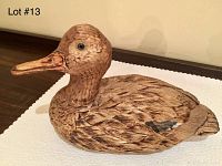 Side view of vintage wooden duck decoy showing detailed hand-carved feathers and painted accents.